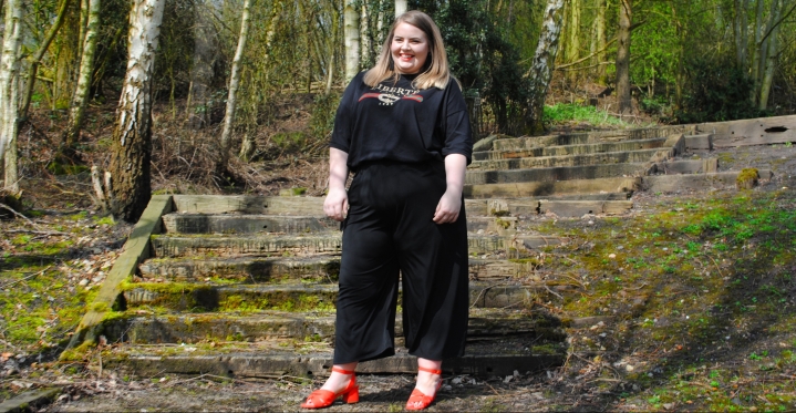 Plus Size girl seen wearing an all black outfit with block colour (coral) sandals